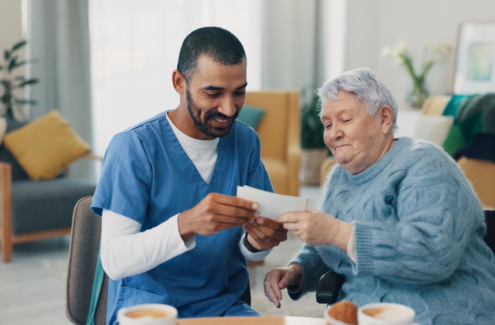 A caregiver looks at photographs with a senior.